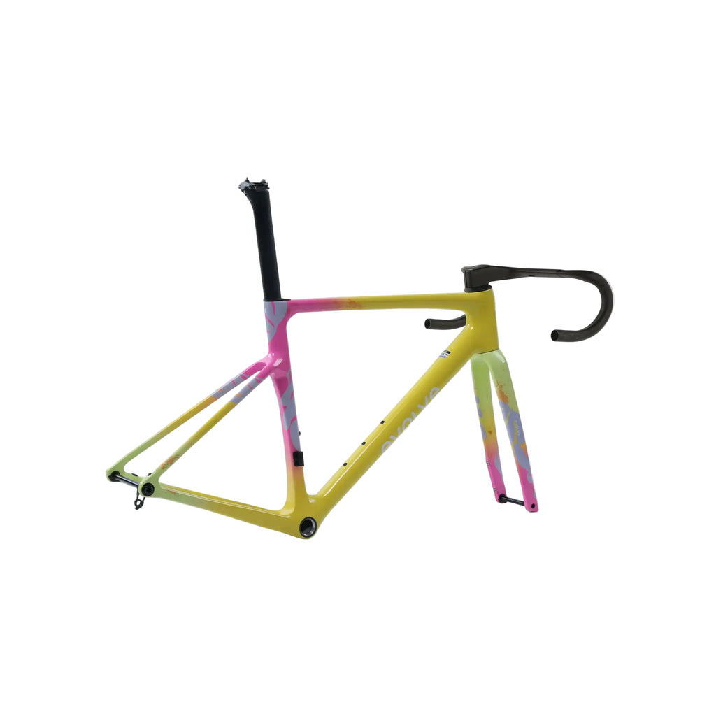 A bicycle frame with a vibrant yellow base and pink, green, and blue tie-dye accents, shown with black drop handlebars and black seat post on a light gray background.