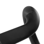 Close-up of a matte black curved chair arm or structural component against a light gray studio background.